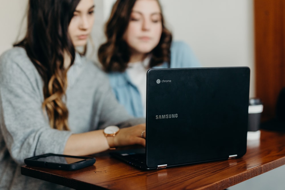 two women using a black Samsung Chromebook