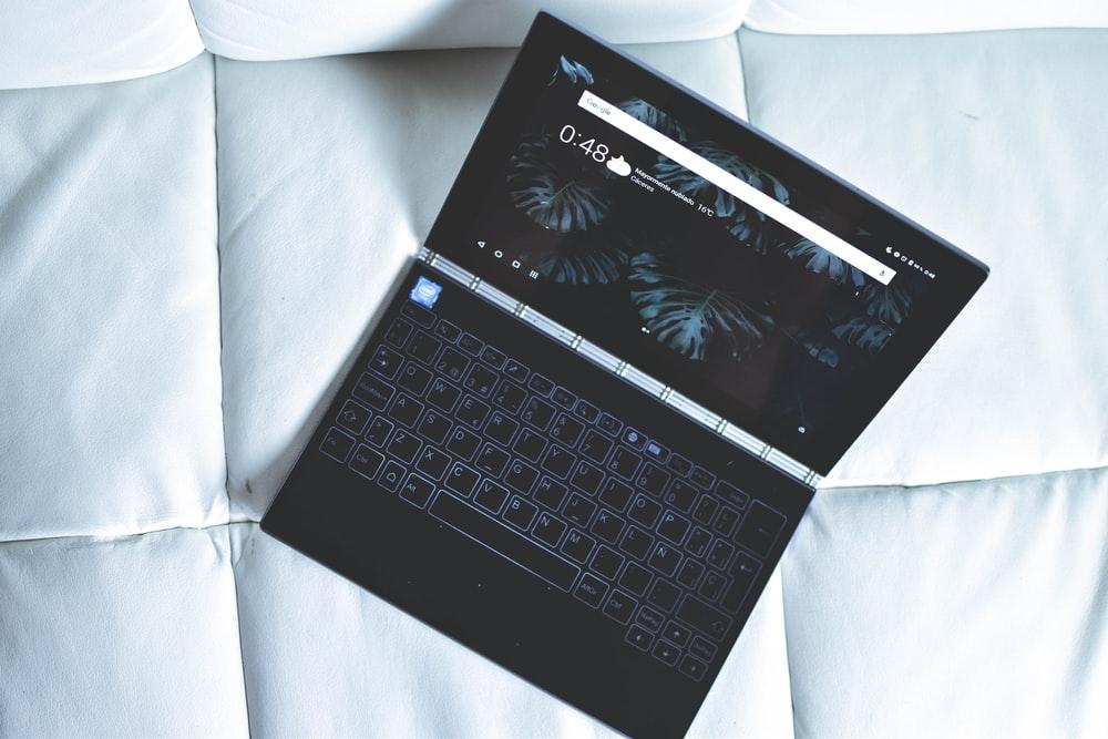 laptop placed on white quilted surface